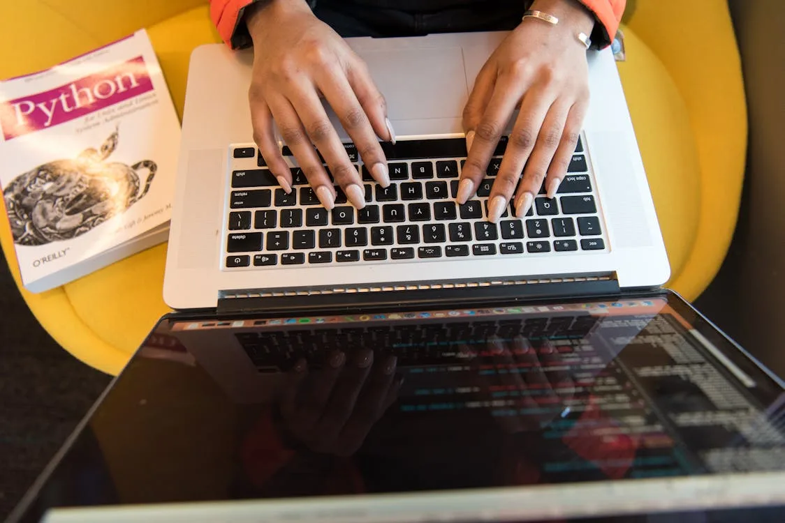 Person at a desk reviewing a document on a laptop computer, looking concerned