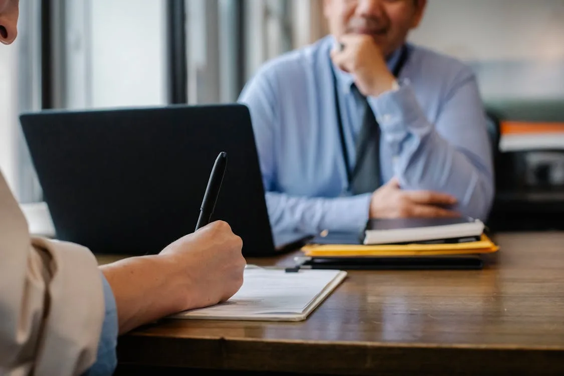 Person reviewing documents on a laptop at a desk